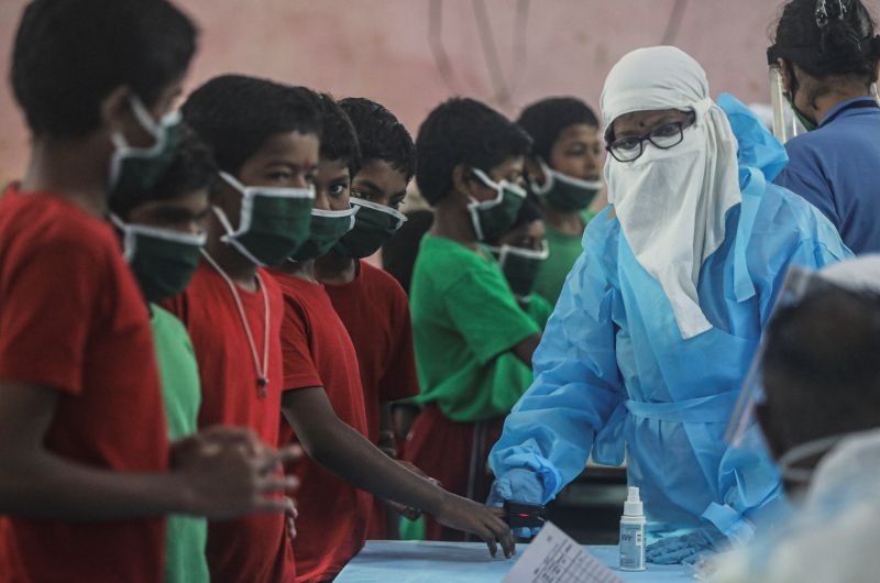 A health worker in personal protective equipment (PPE) checks the pulse of a child at a children's home during a check up campaign for the coronavirus disease (COVID-19) in Mumbai on July 28, 2020. (REUTERS Photo)