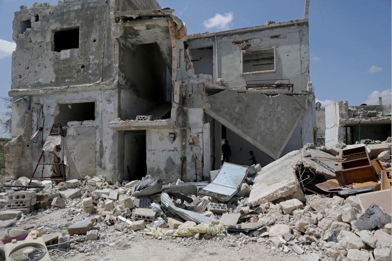 Saher al-Ali's family members stand inside their damaged house in the rebel-held town of Nairab,  Idlib region, Syria on April 17, 2020. (REUTERS File Photo)