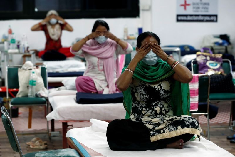 People suffering from the coronavirus disease (COVID-19) perform yoga inside a care centre for COVID-19 patients at an indoor sports complex in New Delhi on July 21, 2020. (REUTERS Photo)