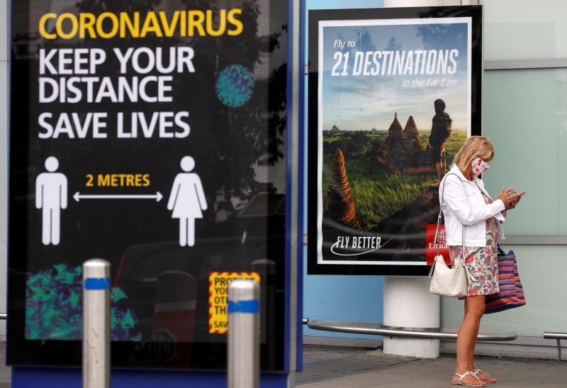 A passenger wearing a protective mask is pictured after arriving at Birmingham Airport following the outbreak of the coronavirus disease (COVID-19) in Birmingham, Britain on July 27, 2020. (REUTERS Photo)