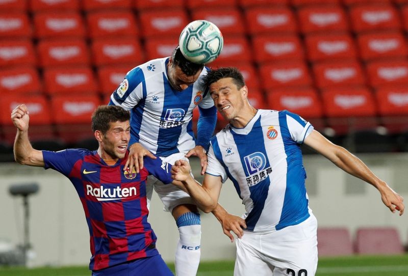 Barcelona's Sergi Roberto in action with Espanyol's Bernardo Espinosa and Raul de Tomas, as play resumes behind closed doors following the outbreak of the coronavirus disease (COVID-19) REUTERS/Albert Gea