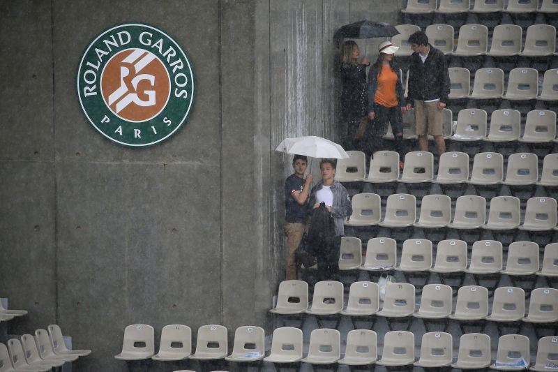 People hold umbrellas to protect themselves from the rain. REUTERS/Gonzalo Fuentes