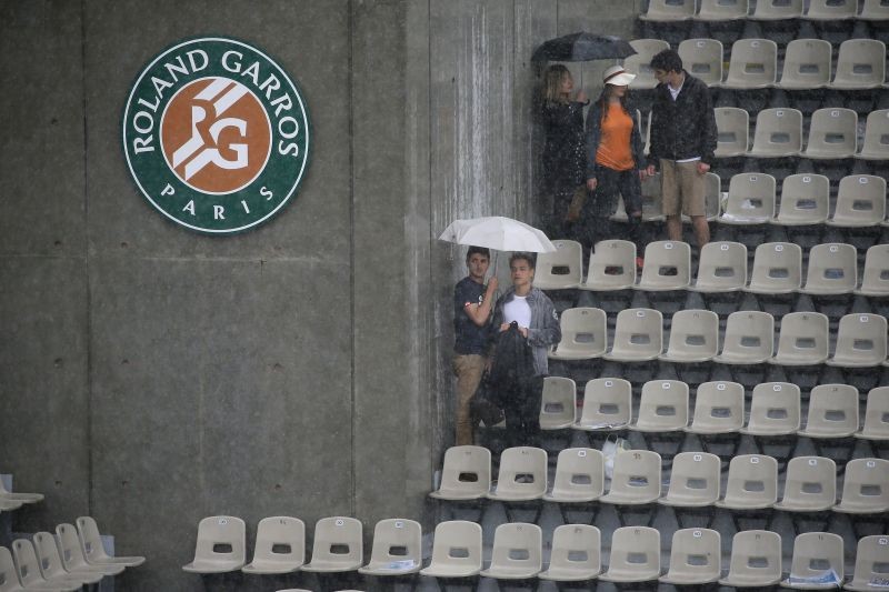 People hold umbrellas to protect themselves from the rain. REUTERS/Gonzalo Fuentes
