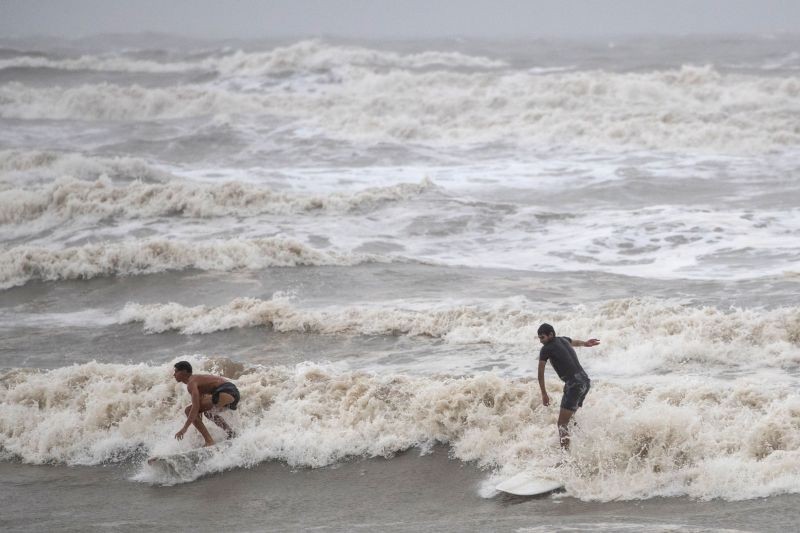 Local residents Alejandero Carcano, 16, and Jesse Garewal, 18, surf in  high swells from Hurricane Hanna in Galveston, Texas, US on July 25, 2020. (REUTERS Photo)