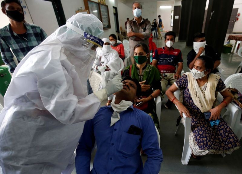 A healthcare worker wearing personal protective equipment (PPE) takes swab from a teacher of a municipal school for a rapid antigen test at a community center, amidst the coronavirus disease (COVID-19) outbreak, in Ahmedabad on July 27. (REUTERS Photo)