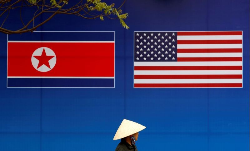 A person walks past a banner showing North Korean and U.S. flags ahead of the North Korea-U.S. summit in Hanoi, Vietnam on February 25, 2019. (REUTERS File Photo)