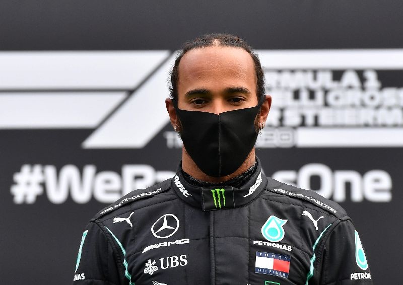 Formula One F1 - Steiermark Grand Prix - Red Bull Ring, Spielberg, Styria, Austria - July 12, 2020   Mercedes' Lewis Hamilton wears a protective face mask as he celebrates winning the race on the podium, following the resumption of F1 after the outbreak of the coronavirus disease (COVID-19)    Joe Klamar/Pool via REUTERS