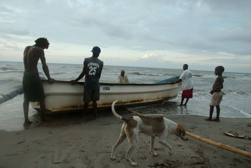 Garifuna men take their boat out of the sea after fishing near the community of Sambo Creek on the northern shore of Honduras on May 7, 2005. (REUTERS File Photo)