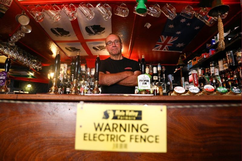 Landlord Johnny McFadden, 61, poses for a photo at the bar area of The Star Inn, where an electric fence has been installed at the bar area to ensure customers are socially distanced from staff while ordering drinks, following the outbreak of the coronavirus disease (COVID-19), in in St Just, Cornwall, Britain on July 14, 2020. (REUTERS Photo)