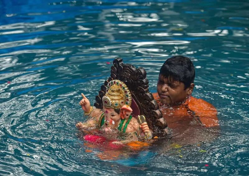  A civic worker carries an idol of elephant-headed Hindu deity Ganesha for immersion in an artificial pond, during one and a half-day of Ganesha Visarjan, at Dadar in Mumbai, Sunday, Aug. 23, 2020. (PTI Photo)
