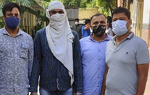 Delhi Police with an alleged IS operative,  2nd left, after arresting him last night following an exchange of fire and recovery of Improvised Explosive Devices (IEDs) from central Delhi's Ridge Road area, in New Delhi, on Saturday. Photograph: PTI Photo