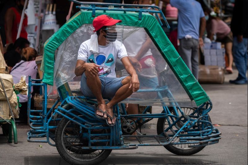 A rickshaw driver wears a face mask and a makeshift face shield made of a water bottle, following their mandatory use in all public transportation, amid the coronavirus disease (COVID-19) outbreak in Manila, Philippines on August 17, 2020. (REUTERS Photo)