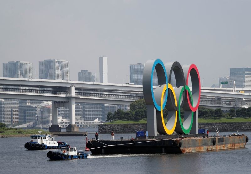 Boats tow the giant Olympic rings, which are being temporarily removed for maintenance, amid the coronavirus disease (COVID-19) outbreak, at the waterfront area at Odaiba Marine Park in Tokyo, Japan August 6, 2020. REUTERS/Kim Kyung-Hoon