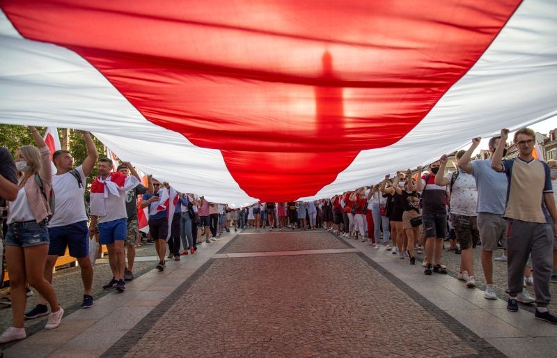People carry a large historical Belarusian flag during a march in solidarity with the people of Belarus following the country's disputed presidential election, in Bialystok, Poland on August 20, 2020. (REUTERS Photo)