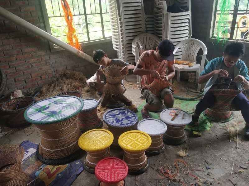 Children from BMSCH engaged in weaving murahs (local bamboo stools).