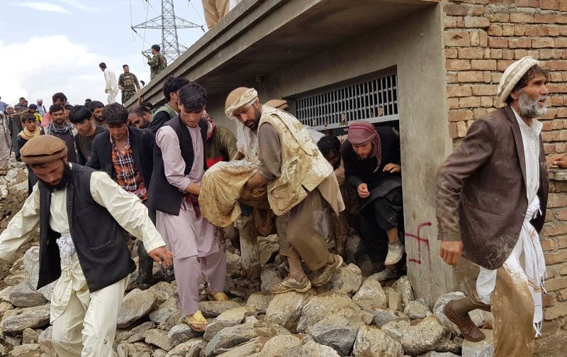 Men carry an injured person out of a house after floods in Charikar, capital of Parwan province, Afghanistan on August 26. (REUTERS Photo)