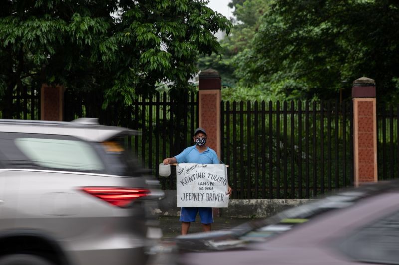 A jeepney driver who lost livelihood amid the coronavirus disease (COVID-19) outbreak begs for financial support on a roadside in Quezon City, Metro Manila, Philippines on July 30, 2020. (REUTERS File Photo)