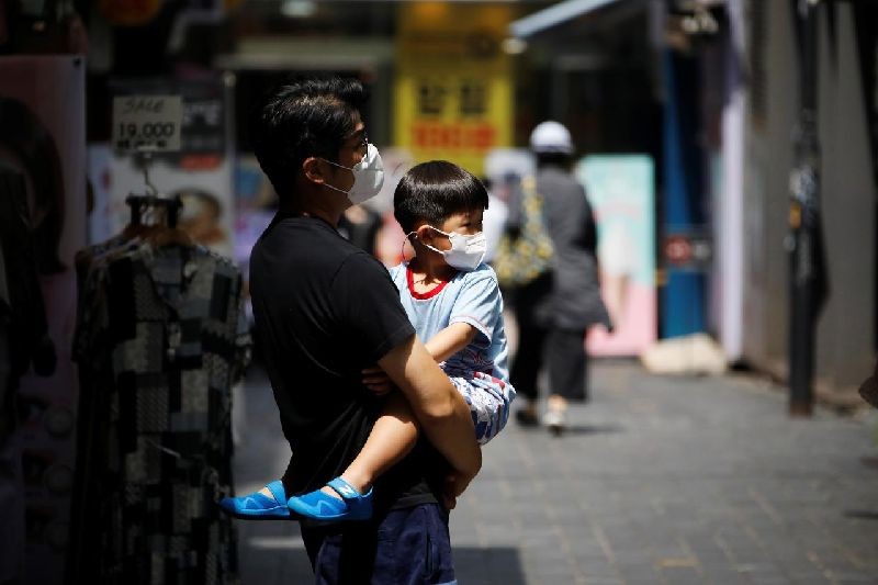 A man holds his son as they shop at Myeongdong shopping district which is nearly empty amid the coronavirus disease (COVID-19) pandemic in Seoul, South Korea, August 24, 2020. REUTERS/Kim Hong-Ji