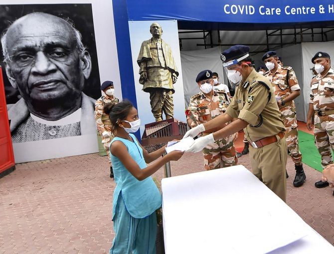 ITBP ADG Amrit Mohan Prasad presents certificate to a girl as she is discharged after recovering from COVID-19 at the Sardar Patel Covid Care Centre in New Delhi, on Monday. Photograph: Ravi Choudhary/PTI Photo