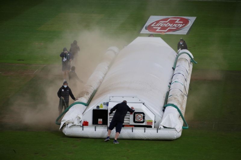 Groundstaff put the covers on the pitch after rain and bad light stopped play, as play resumes behind closed doors following the outbreak of the coronavirus disease (COVID-19) Alastair Grant/Pool via REUTERS
