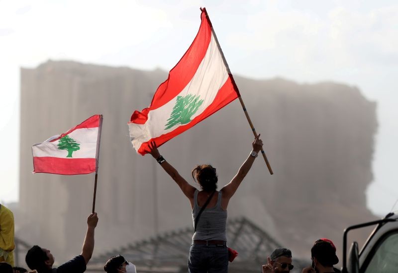 Demonstrators wave Lebanese flags during protests near the site of a blast at Beirut's port area, Lebanon on August 11, 2020. (REUTERS Photo)
