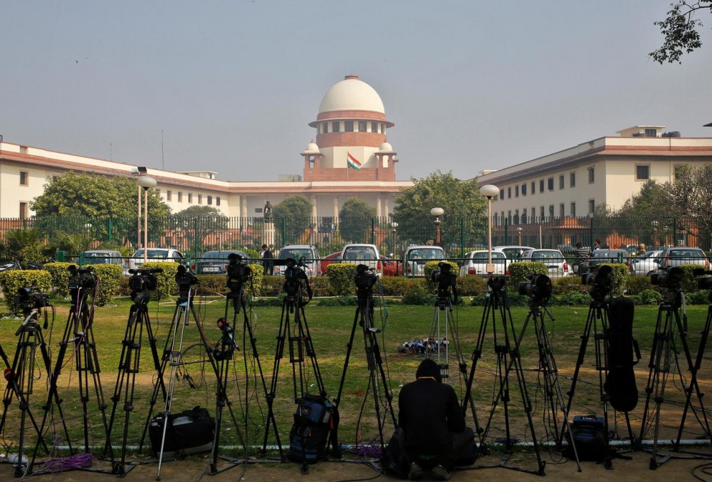 A television journalist sets his camera inside the premises of the Supreme Court in New Delhi, February 18, 2014. REUTERS/Anindito Mukherjee/Files