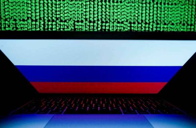 A Russian flag is seen on the laptop screen in front of a computer screen on which cyber code is displayed, in this illustration picture taken on March 2, 2018. (REUTERS File Photo)