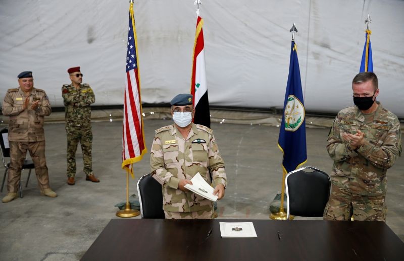 Maj. Gen. Kenneth P. Ekman, Deputy Commander of Combined Joint Task Force-Operation Inherent Resolve, claps as he stands next to Brigadier General Salah Abdullah during a handover ceremony of Taji military base from US-led coalition troops to Iraqi security forces, in the base north of Baghdad, Iraq on August 23, 2020. (REUTERS Photo)