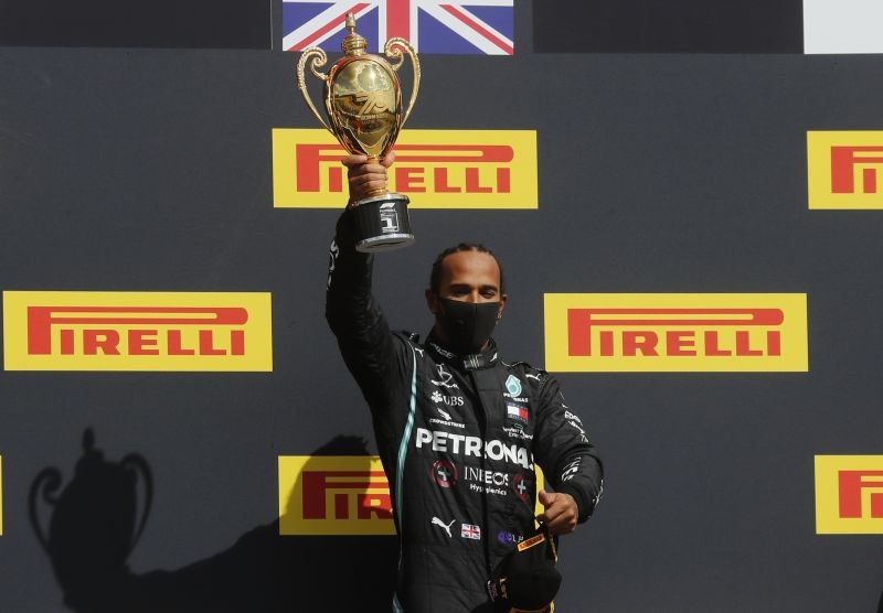 Formula One F1 - British Grand Prix - Silverstone Circuit, Silverstone, Britain - August 2, 2020 Mercedes' Lewis Hamilton celebrates winning the race on the podium with the trophy Pool via REUTERS/Frank Augstein