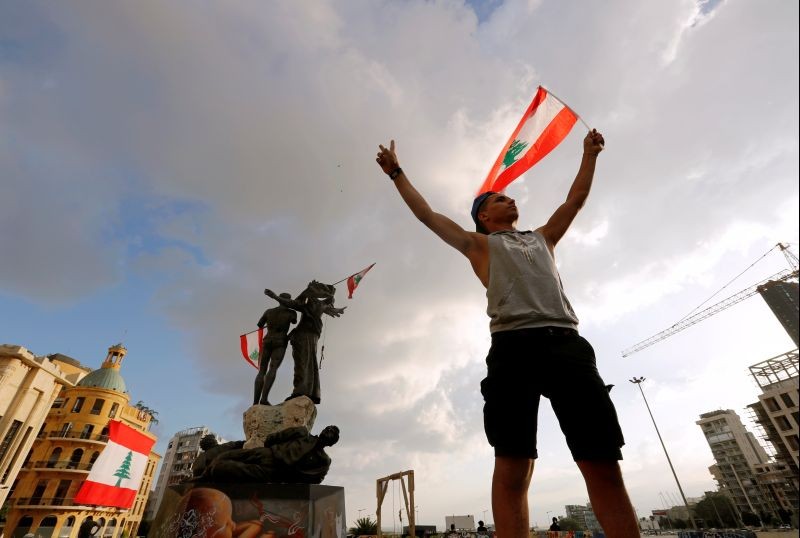 A demonstrator holds the Lebanese flag in Martyrs' Square where protests are held following Tuesday's blast in Beirut, Lebanon on August 9. (REUTERS Photo)