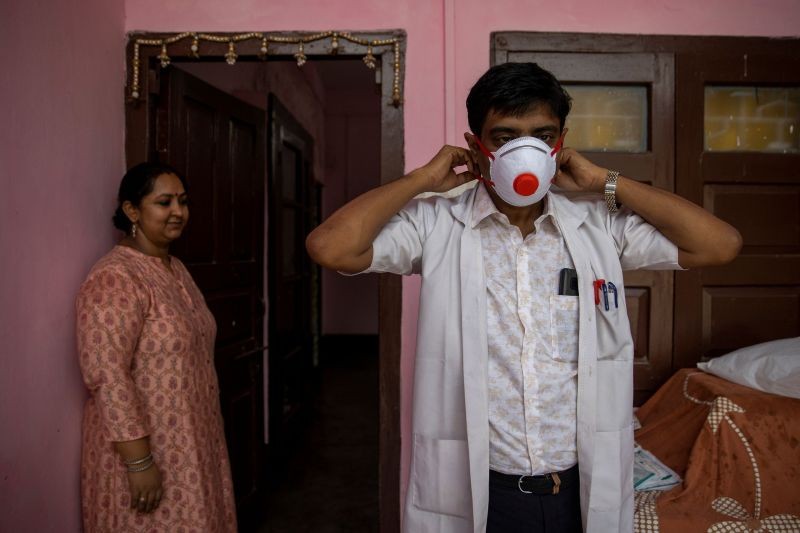 Dr. Kumar Gaurav, 42, a medical professor and consultant psychiatrist who has been named the top official at Jawahar Lal Nehru Medical College and Hospital during the coronavirus disease (COVID-19) outbreak, puts on his personal protective equipment (PPE) as his wife Dr. Mili Jaswal, a psychologist, looks on, at their home in Bhagalpur, Bihar on July 27, 2020. Now, with some doctors struck down by the coronavirus and others refusing to work, Gaurav has been named the top official at the hospital, despite being one of its most junior consultants â€“ and suffering from diabetes and hypertension, two risk factors for severe COVID-19. But Gaurav says he felt compelled to volunteer for the job. "A lot of my colleagues refused," he says. "I had to take up the responsibility." (REUTERS File Photo)