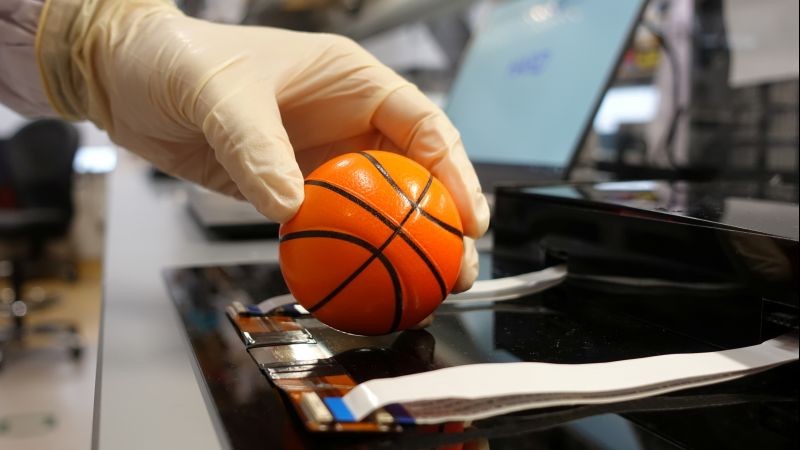 Dr. Benjamin Tee, Assistant Professor of Materials Science and Engineering at the National University of Singapore (NUS), demonstrates how his device can detect the texture of a soft stress ball at a lab in NUS, Singapore on July 27, 2020. (REUTERS File Photo)