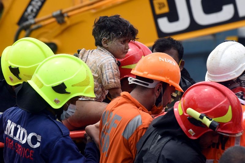 Rescue workers carry Mohammed Bangi, a four-year-old boy, after he was rescued from the rubble at the site of a collapsed five-storey building in Mahad in Raigad district in the western state of Maharashtra, India, August 25, 2020. REUTERS/Stringer