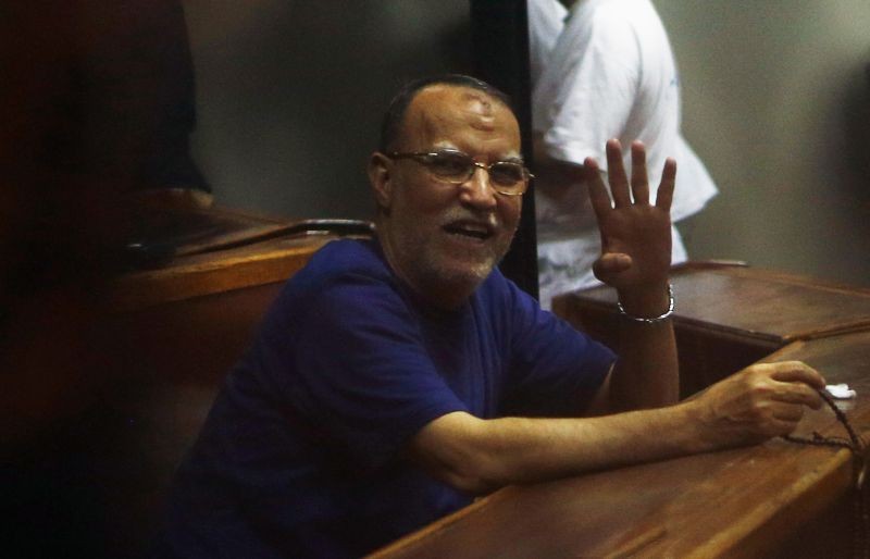 Deputy head of the Freedom and Justice Party Essam El-Erian waves with the Rabaa sign, symbolizing the support of the Muslim Brotherhood, during his trial with other leaders of the Muslim Brotherhood on charges of spying and terrorism at a court in the police academy on the outskirts of Cairo on November 18, 2014.  (REUTERS File Photo)