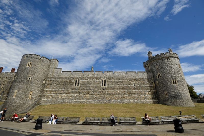 People sit on benches outside of Windsor Castle, amid the spread of the coronavirus disease (COVID-19), in Windsor, Britain on August 5, 2020. (REUTERS Photo)