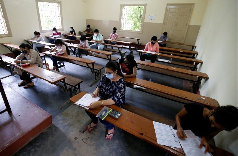 Students wearing protective face masks take a Gujarat Common Entrance Test (GUJCET) while maintaining social distance amidst the coronavirus disease (COVID-19) outbreak, inside a classroom in Ahmedabad on August 24, 2020. (REUTERS Photo)