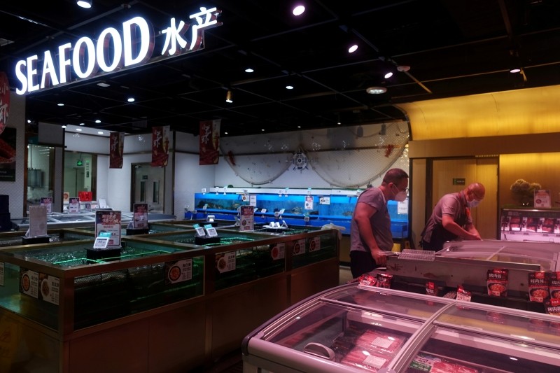 A staff member attends to a customer at a live seafood section inside a supermarket, following a new outbreak of the coronavirus disease (COVID-19), in Beijing, China June 20, 2020. (REUTERS File Photo)