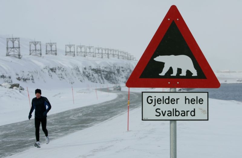 A runner passes a sign warning of the dangers of polar bears on the Norwegian Arctic archipelago of Svalbard on April 24, 2007. (REUTERS File Photo)