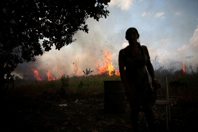 Miraceli de Oliveira reacts as the fire approaches her house in an area of Amazon rainforest, near Porto Velho, Rondonia State, Brazil on August 16, 2020. (REUTERS Photo)