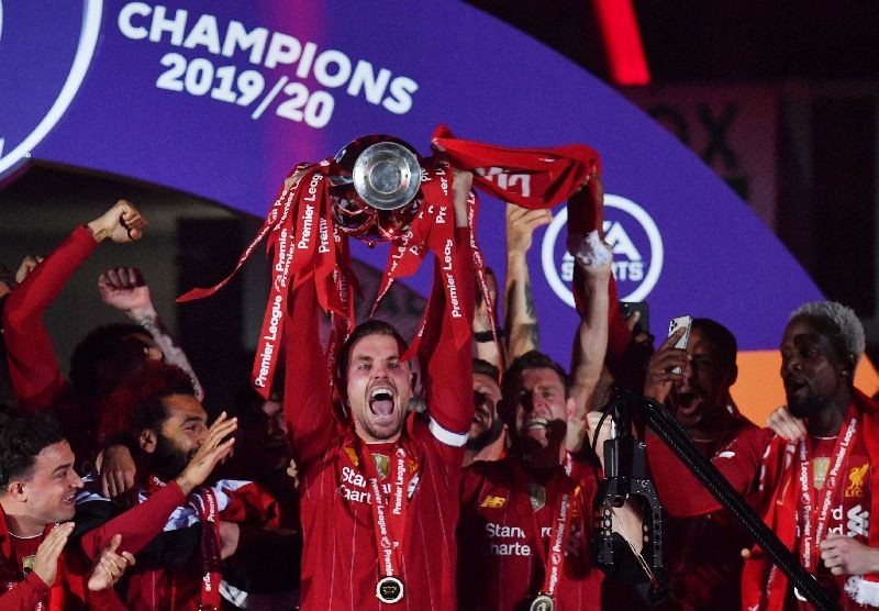 FILE PHOTO: Soccer Football - Premier League - Liverpool v Chelsea - Anfield, Liverpool, Britain - July 22, 2020 Liverpool's Jordan Henderson with team mates celebrates with the trophy after winning the Premier League Pool via REUTERS/Paul Ellis