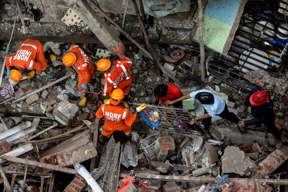 National Disaster Response Force (NDRF) officials and firemen remove debris as they look for survivors after a three-storey residential building collapsed in Bhiwandi on the outskirts of Mumbai, India, September 21, 2020. (REUTERS/Francis Mascarenhas)