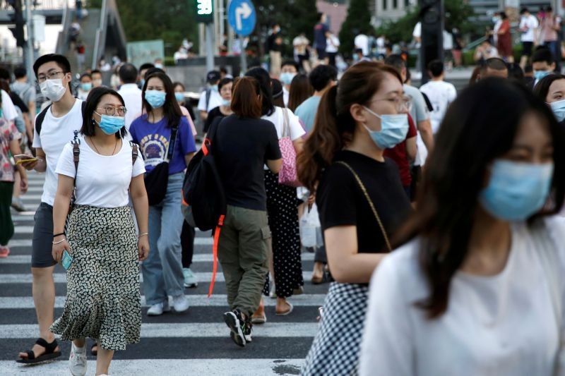 People wearing face masks following the coronavirus disease (COVID-19) outbreak walk across a street at a shopping area in Beijing, China August 25, 2020. (REUTERS File Photo)