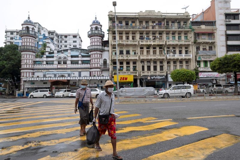 Men wearing protective masks cross a street amid the COVID-19 pandemic after authorities announced a stay-at-home order, in Yangon, Myanmar on September 21. (REUTERS Photo)