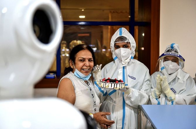 COVID-19 patient Renu Arora interacts with her family members via a robot as she celebrates her birthday with health workers inside a COVID-19 dedicated ward, at Yatharta Hospital in Greater Noida. Photograph: Arun Sharma/PTI Photo