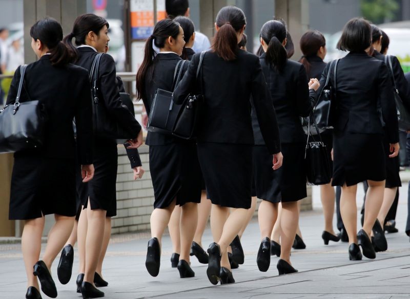 Female office workers wearing high heels, clothes and bags of the same colour make their way at a business district in Tokyo, Japan on June 4, 2019. (REUTERS File Photo)