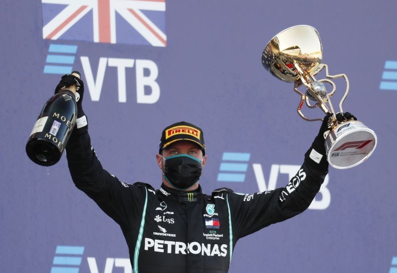 Mercedes' Valtteri Bottas celebrates with the trophy on the podium after winning the race. Pool via REUTERS/Yuri Kochetkov
