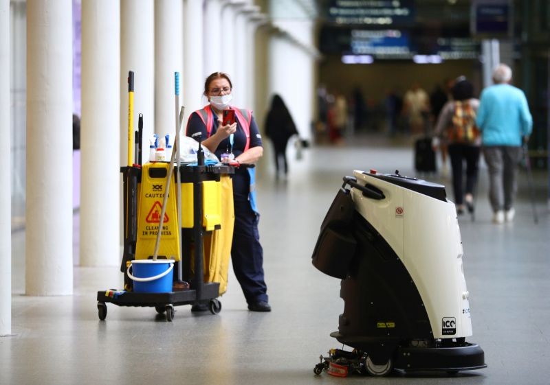 A cleaner photographs an Ultrasonic Disinfection Atomiser cleaning robot, known as an Eco Bot 50 as it cleans St Pancras International station, amid the coronavirus disease (COVID-19) outbreak in London, Britain on September 23, 2020. (REUTERS Photo)