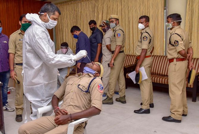 A medic collects a nasal sample from a police constable of Assembly security staff for COVID-19 test, before the monsoon session, inside state assembly premises, in Hyderabad, on Saturday. Photograph: PTI Photo