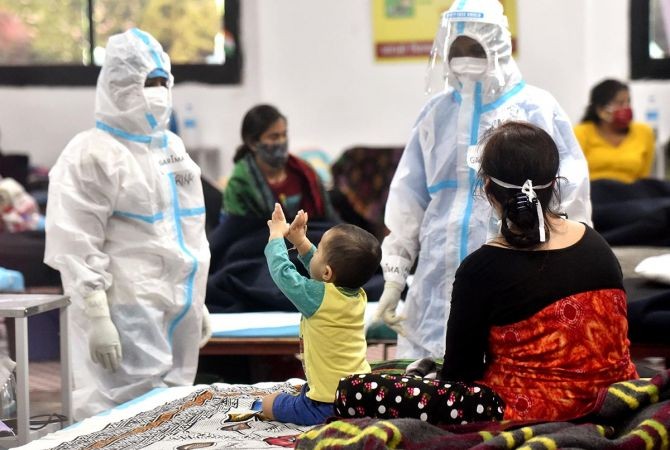 Health workers in PPE kit playing with a child at the Commonwealth Games Village sports complex, temporarily converted into a COVID-19 care centre, in New Delhi. Photograph: Rahul Singh/ANI Photo