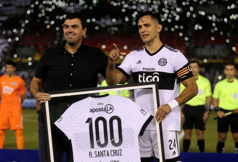 Paraguay's Roque Santa Cruz (R) receives a prize from President of Olimpia Marcos Trovato for his 100th game before the match. REUTERS/Jorge Adorno/Files